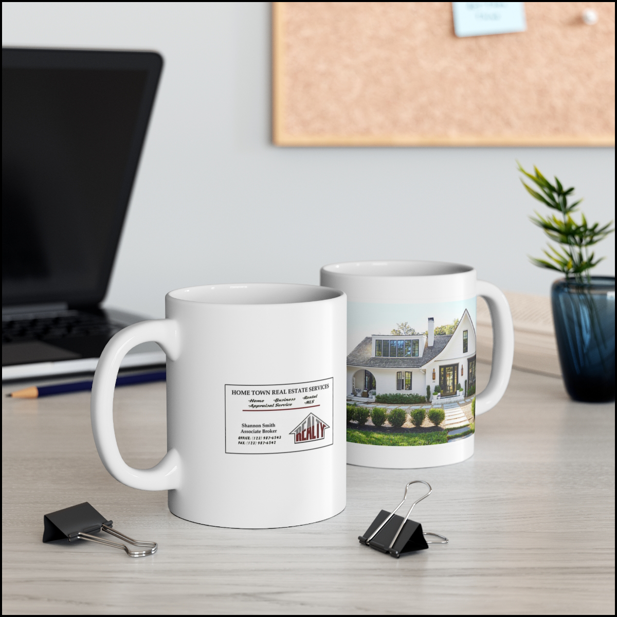 Two real estate personalized closing mugs on a desk with a laptop and office supplies, featuring a picture of the house and business card.